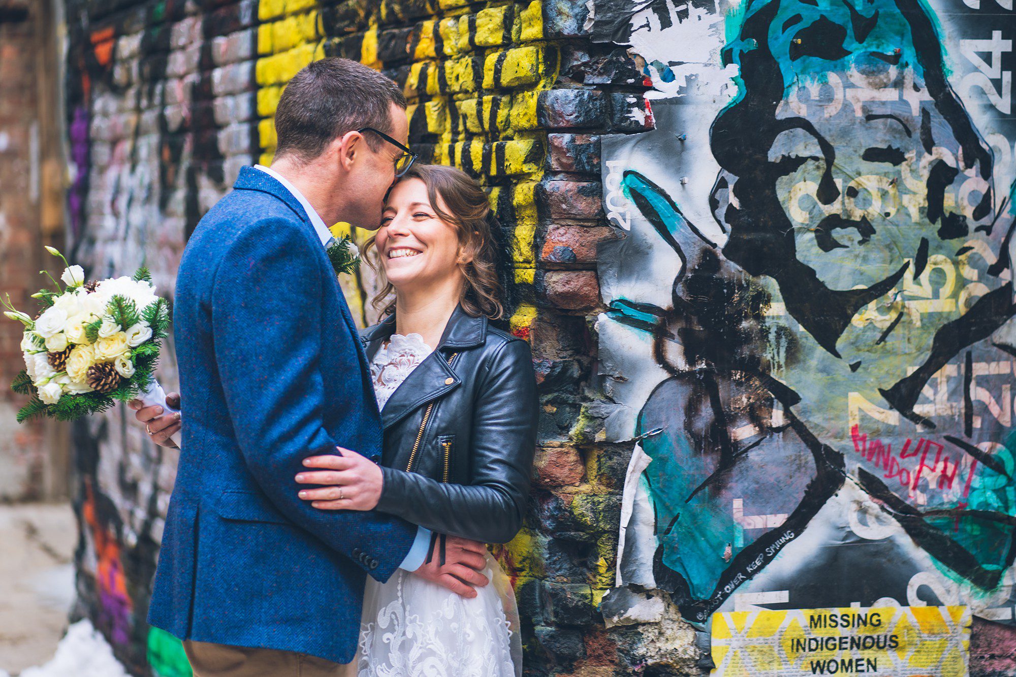 Bride and groom posing in front of a New York graffiti wall by Sascha Reinking Photography, New York Elopement Photographer